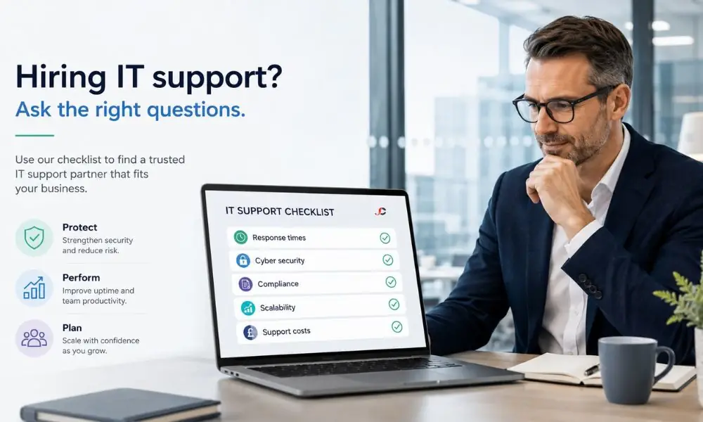 Business leader reviewing questions to ask before hiring IT support, checklist on laptop in modern UK office.